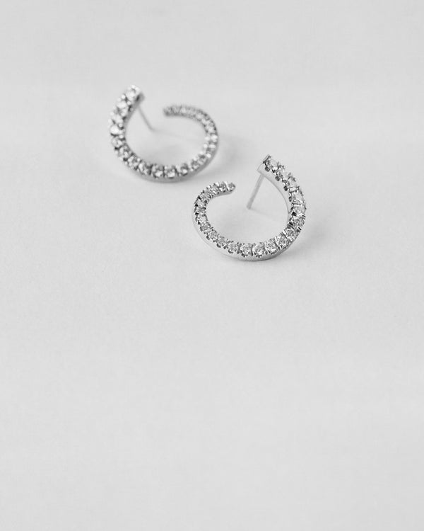 Silver hoop earrings with clear stones on a light gray background